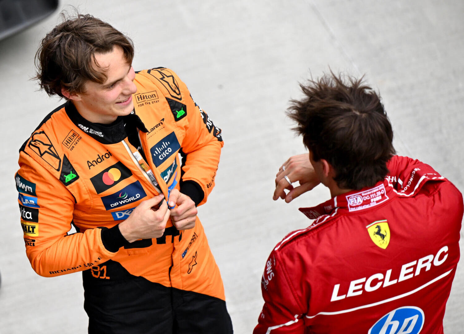 Oscar Piastri, McLaren, and pole-sitter Charles Leclerc, Scuderia Ferrari, talk after Qualifying at the 2025 F1 Hungarian Grand Prix.