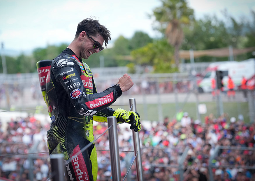 Fabio Di Giannantonio celebrates his MotoGP victory with a raised fist, wearing Pertamina Enduro VR46 Racing Team leathers.